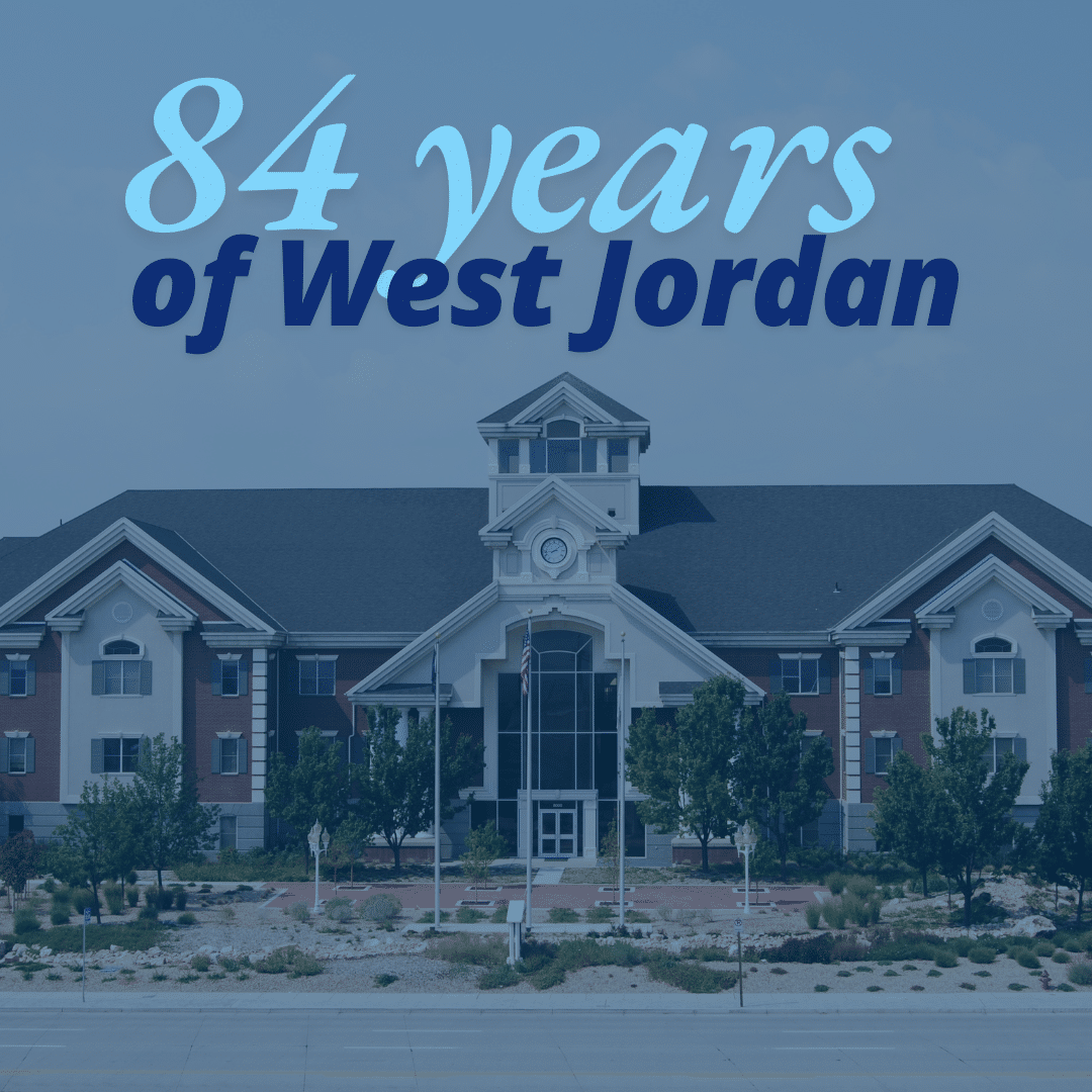 A large building with a peaked roof stands behind a manicured lawn and pathway. Text overlay reads: 84 years of West Jordan.